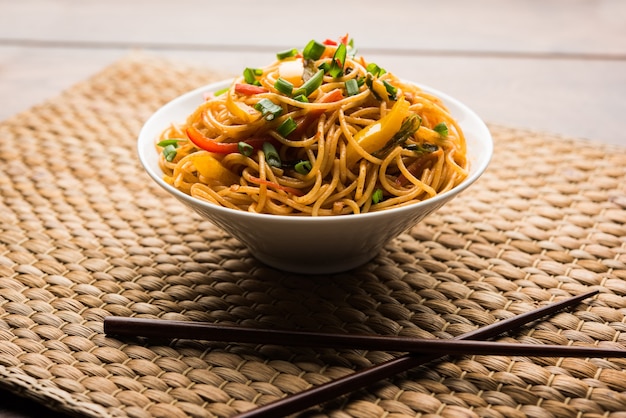 Schezwan Noodles o verdure Hakka Noodles o chow mein è una popolare ricetta indo-cinese, servita in una ciotola o in un piatto con bacchette di legno. messa a fuoco selettiva