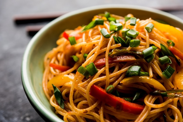 Schezwan Noodles o verdure Hakka Noodles o chow mein è una popolare ricetta indo-cinese, servita in una ciotola o in un piatto con bacchette di legno. messa a fuoco selettiva