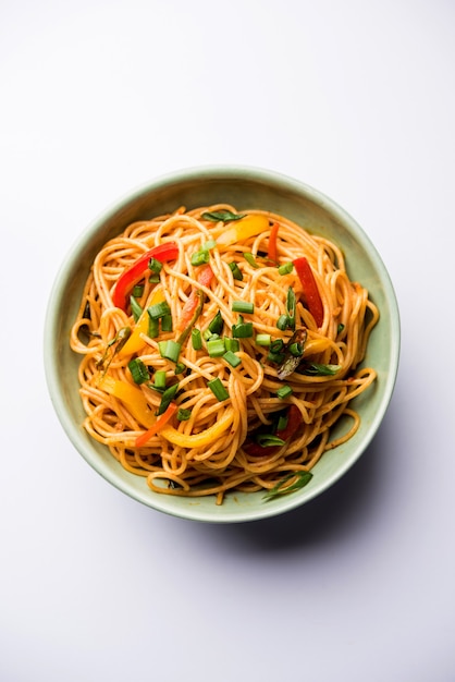 Schezwan Noodles o verdure Hakka Noodles o chow mein è una popolare ricetta indo-cinese, servita in una ciotola o in un piatto con bacchette di legno. messa a fuoco selettiva