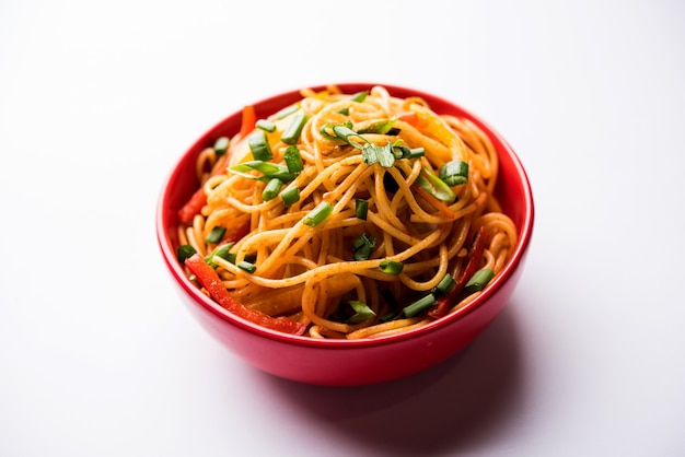 Schezwan Noodles o verdure Hakka Noodles o chow mein è una popolare ricetta indo-cinese, servita in una ciotola o in un piatto con bacchette di legno. messa a fuoco selettiva