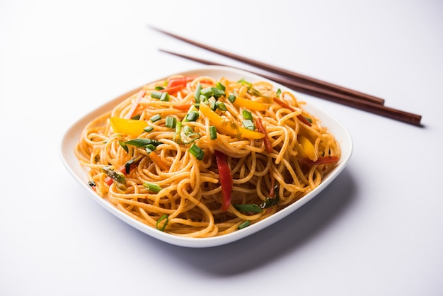 Schezwan Noodles o verdure Hakka Noodles o chow mein è una popolare ricetta indo-cinese, servita in una ciotola o in un piatto con bacchette di legno. messa a fuoco selettiva