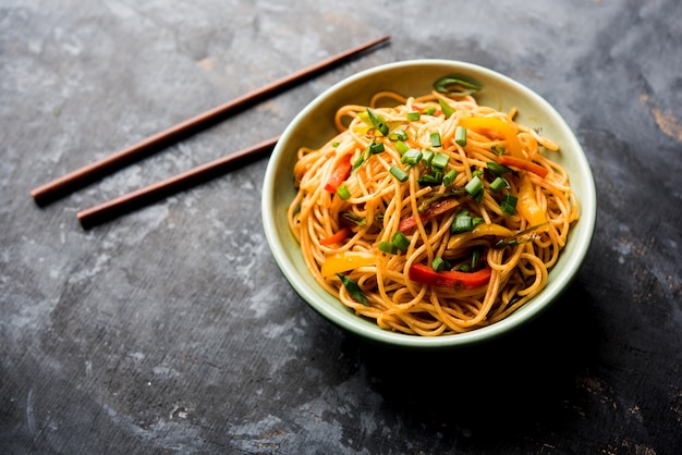 Schezwan Noodles o verdure Hakka Noodles o chow mein è una popolare ricetta indo-cinese, servita in una ciotola o in un piatto con bacchette di legno