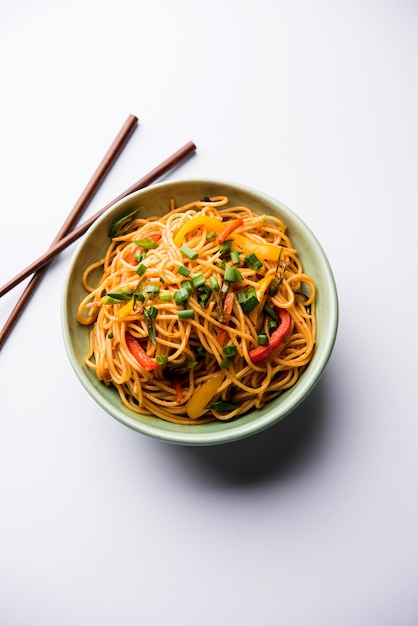 Schezwan Noodles o verdure Hakka Noodles o chow mein è una popolare ricetta indo-cinese, servita in una ciotola o in un piatto con bacchette di legno