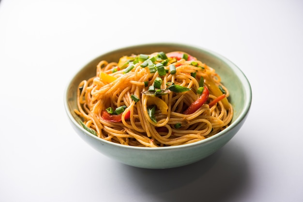 Schezwan Noodles o verdure Hakka Noodles o chow mein è una popolare ricetta indo-cinese, servita in una ciotola o in un piatto con bacchette di legno