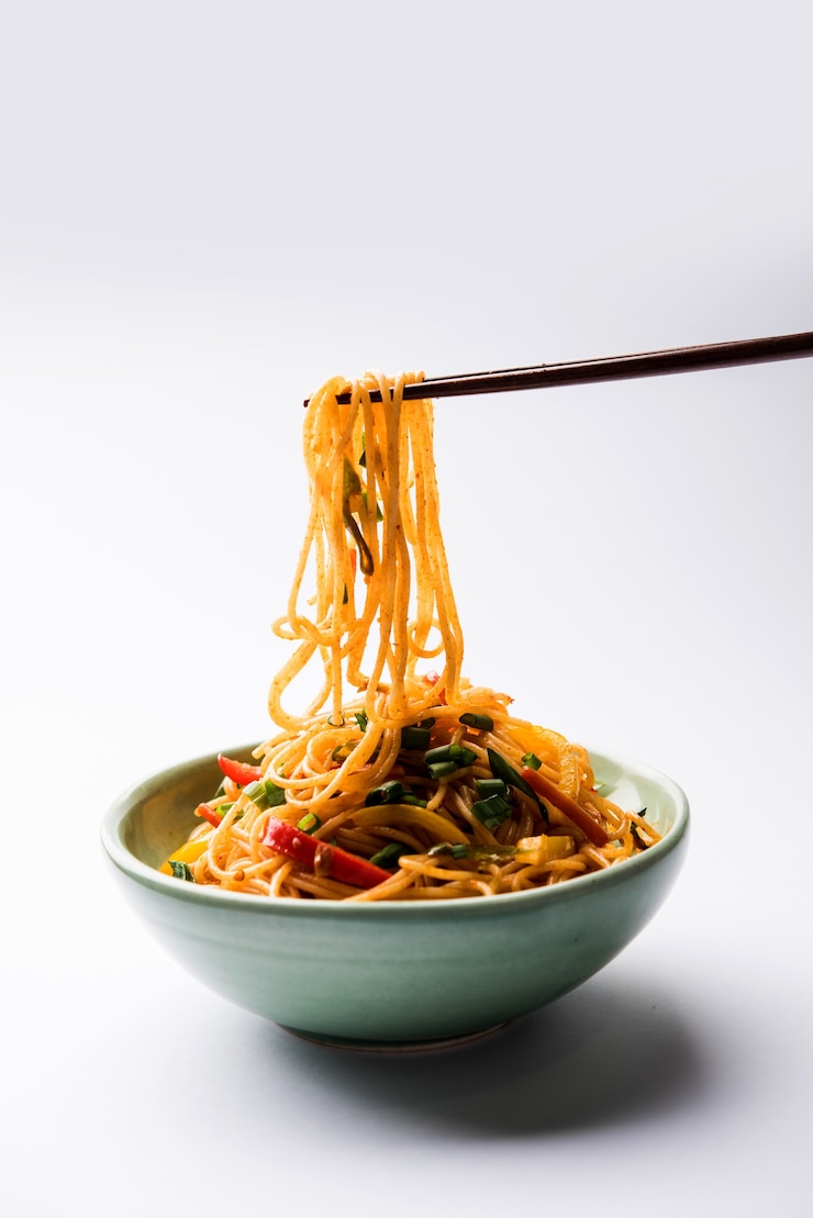 Foto schezwan noodles o verdure hakka noodles o chow mein è una popolare ricetta indo-cinese, servita in una ciotola o in un piatto con bacchette di legno