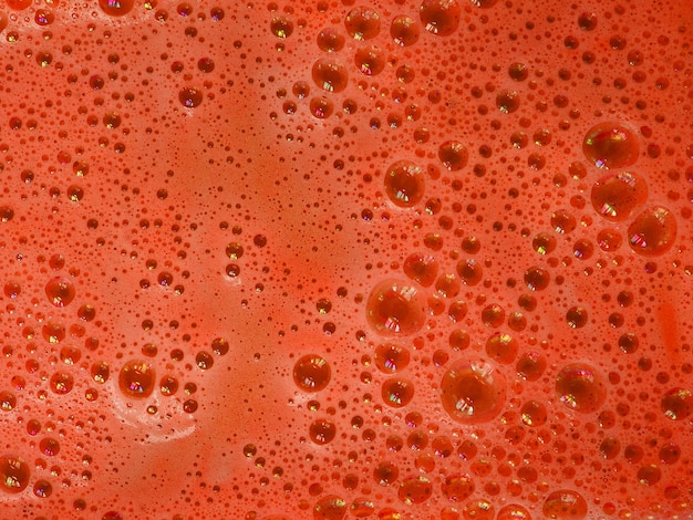 Schiuma da bagno colorata arancione con bolle nell'acqua