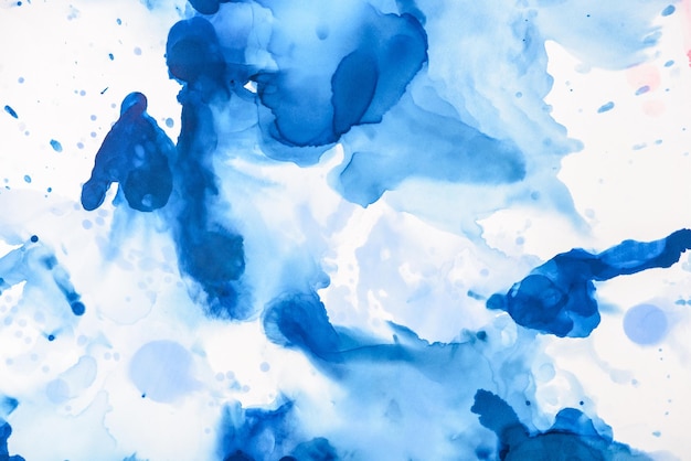 schizzi blu di inchiostro alcolico su bianco come sfondo astratto