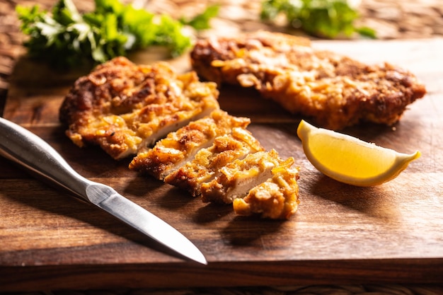 Schnitzel di pollo tradizionale viennese su una tavola di legno.