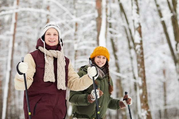 Sciare sorridente delle coppie nella foresta