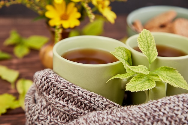 Sciarpa lavorata a maglia con calda tazza di tè.