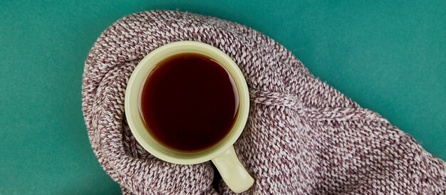 Sciarpa lavorata a maglia con una calda tazza di tè