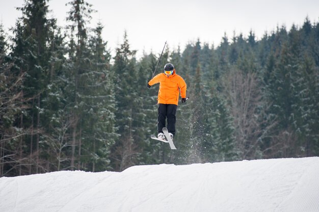 Sciatore al salto dal pendio delle montagne