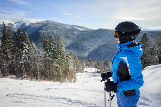 Sciatore femminile contro il fondo delle montagne di inverno e dello ski-lift