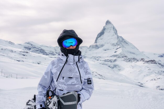 Sciatore in abbigliamento invernale con snowboard Matterhorn Peak Zermatt Svizzera