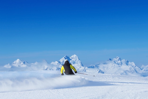 Sciatore sci di discesa in alta montagna, vista posteriore, Solden, Austria
