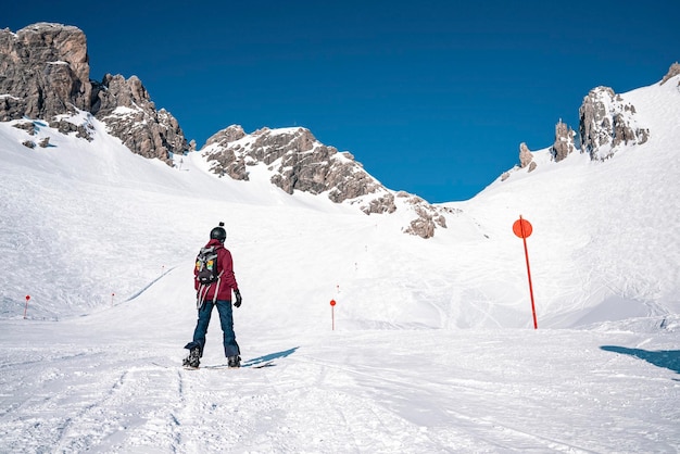 Sciatore snowboard sulla montagna innevata in una giornata di sole