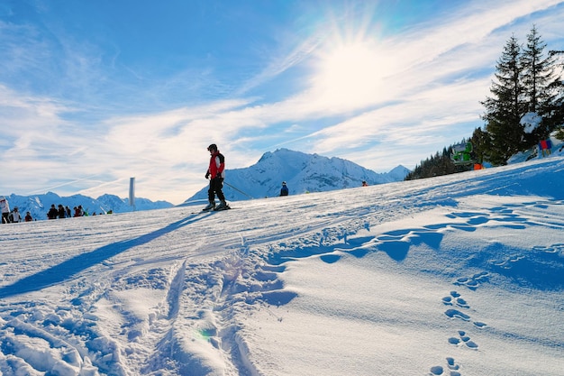 Sciatore uomo che scia sulla stazione sciistica Penken Park in Tirolo a Mayrhofen nella valle Zillertal dell'Austria nelle Alpi invernali. La gente scia sulle montagne alpine con neve bianca e cielo blu. Piste innevate austriache.