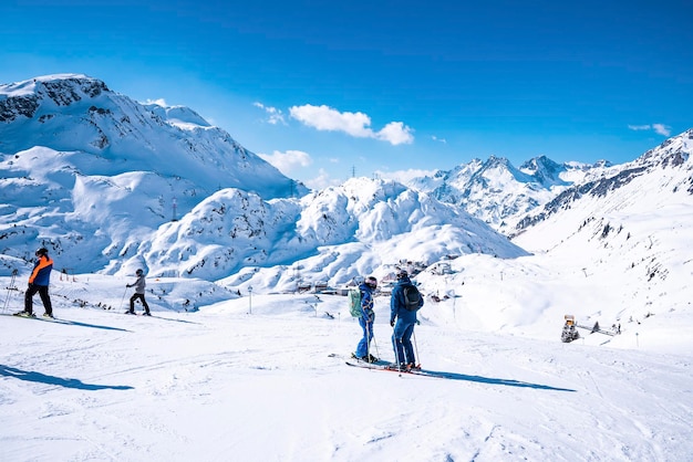 Sciatori con pali in piedi sul pendio di montagna innevato alla stazione invernale