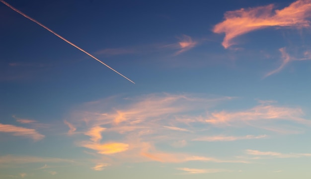 Scie di condensa in un cielo blu e arancione