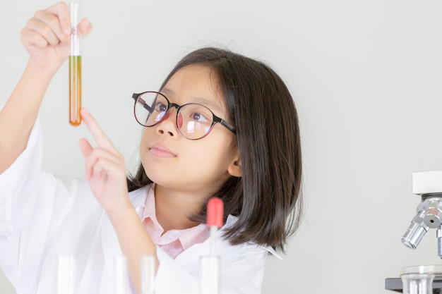 Scienza dei bambini, bambina felice che gioca facendo esperimenti chimici in laboratorio