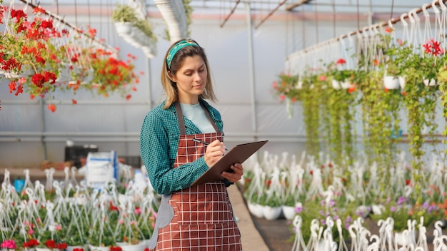 Scienziata americana con un libro di fiori in mano durante un esperimento di ricerca in un giardino di fiori