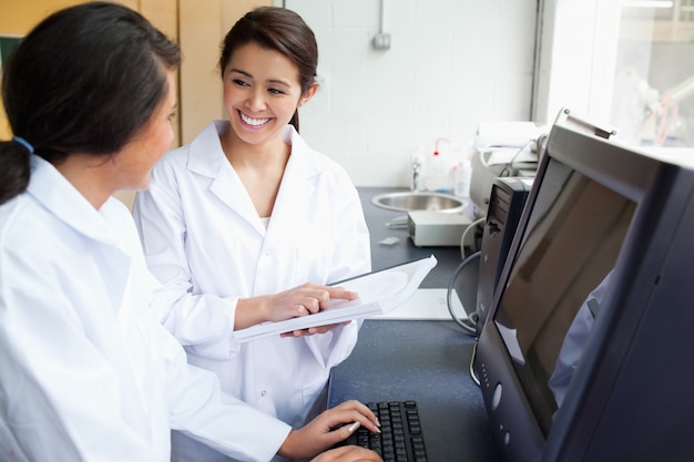 Scienziati sorridenti che lavorano con un monitor