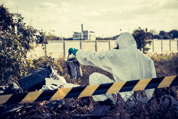 Scienziato asiatico indossare tuta di protezione chimica controllare il pericolo di lavorazione chimica in zone pericolose autenticando le sostanze chimiche pericolose
