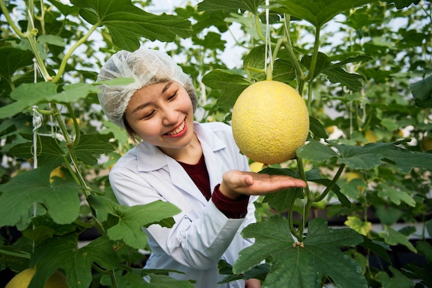 Scienziato asiatico studiando piante e frutti