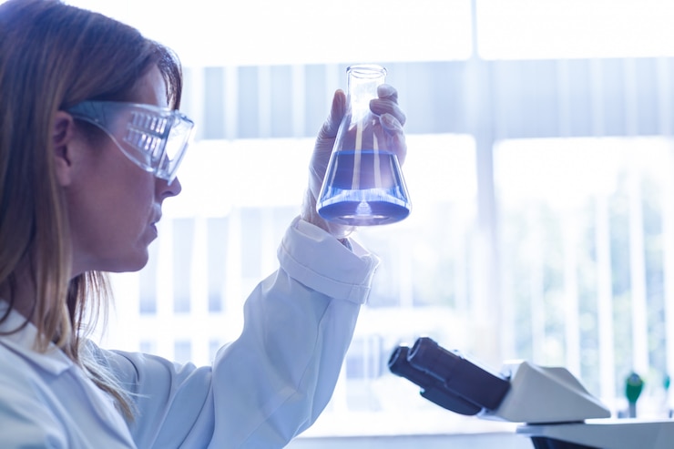 Foto scienziato che sostiene becher di prodotto chimico