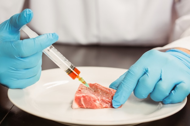 Scienziato dell&#39;alimento che inietta carne cruda