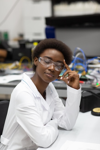 Scienziato donna afroamericana che lavora in laboratorio con strumenti elettronici