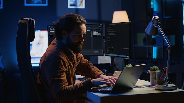 Scienziato informatico che si mette le cuffie mentre sviluppa il codice sul PC