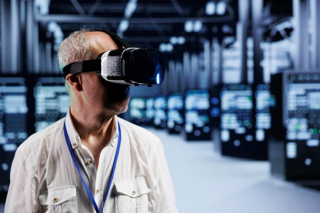 Scienziato informatico invecchiato immerso nella realtà virtuale presso il data center, che esegue la manutenzione dell'hardware. Lavoratore che utilizza il visore VR per ottimizzare le prestazioni del sistema dei server rig, sfruttando la tecnologia all'avanguardia