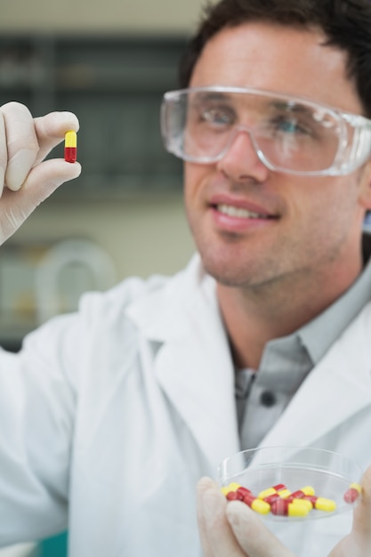 Scienziato maschio che analizza le pillole in laboratorio