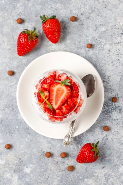 Sciocchezza di panna e fragole con miele e cereali.