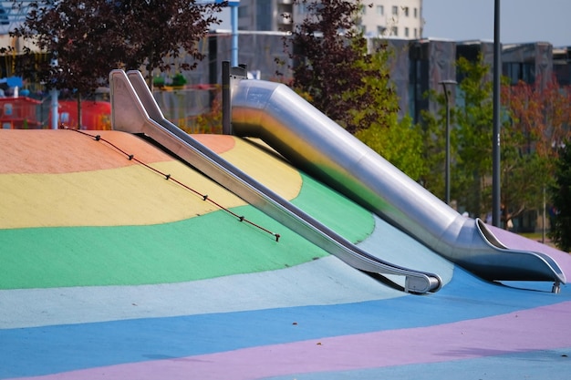 Scivoli per bambini su un parco giochi colorato in un parco cittadino
