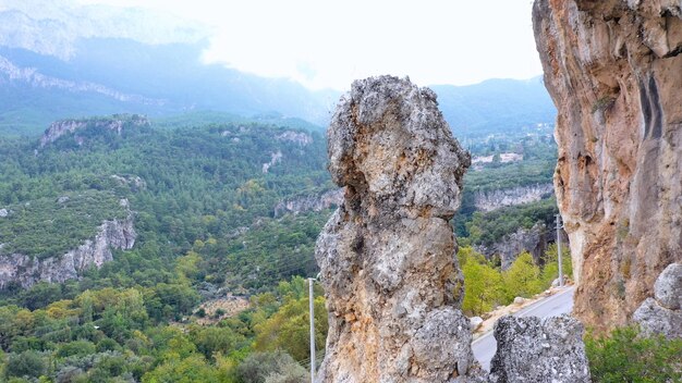 Scogliera rocciosa sullo sfondo della formazione rocciosa panoramica della valle di montagna verde durante il tour della strada di campagna