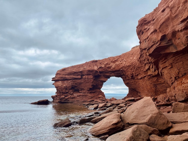 Scogliere di arenaria rossa sotto un cielo coperto a Cavendish Beach, Prince Edward Island, Canada.