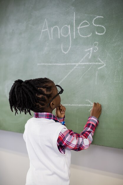 Scolara che fa matematica sulla lavagna in aula