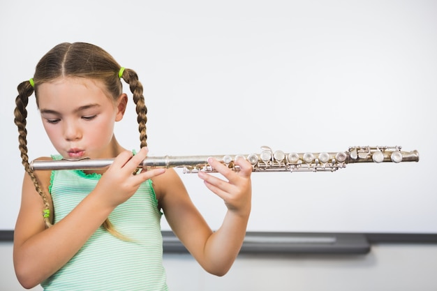Scolara che suona flauto in aula