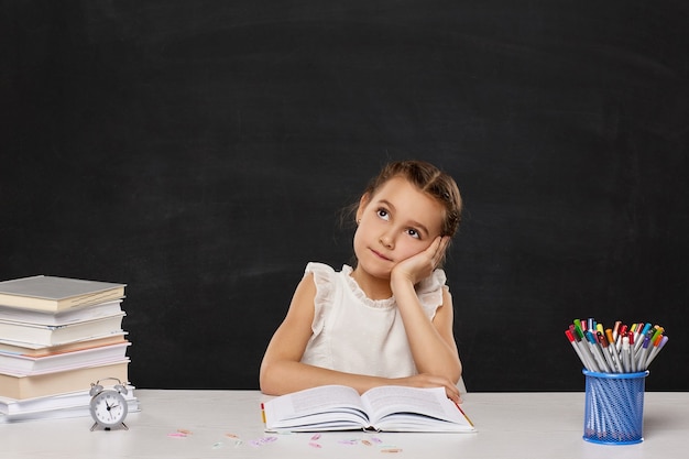 Scolara felice seduta a tavola in classe