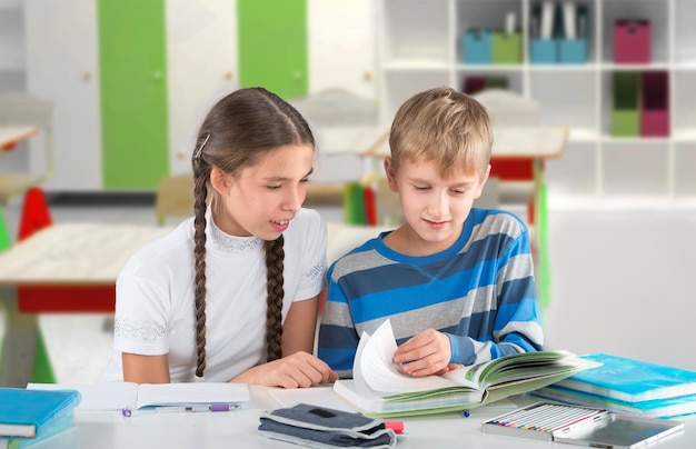 Scolara intelligente che scrive un test e la sua amica che guarda il suo quaderno