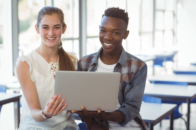 Scolari che tengono computer portatile in aula