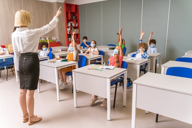 Scolari giocosi che si godono il tempo scolastico e la lezione con l'insegnante e i compagni di classe