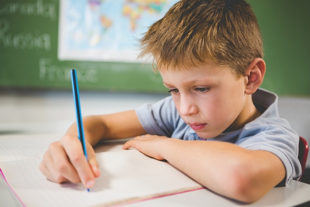 Scolaro che fa i compiti in aula