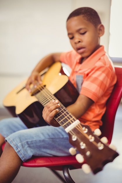 Scolaro che gioca chitarra in aula