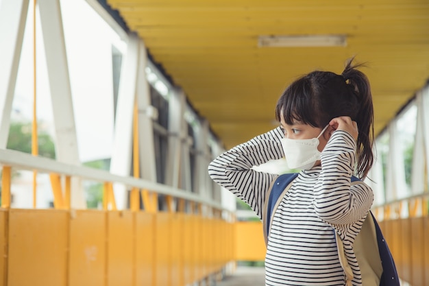 Scolaro che indossa una maschera facciale durante l'epidemia di coronavirus Bambina che torna a scuola