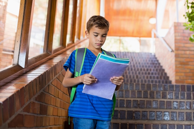 Scolaro che legge un libro sulla scala