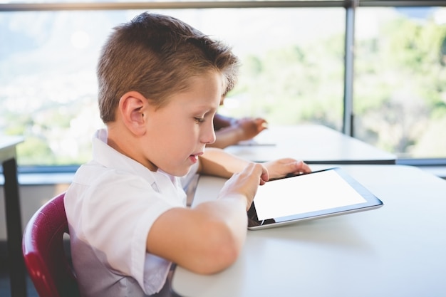 Scolaro che utilizza la compressa digitale nell'aula