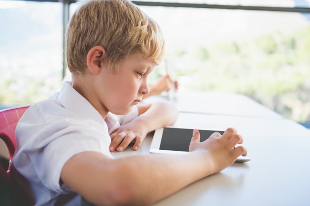 Scolaro che utilizza la compressa digitale nell'aula